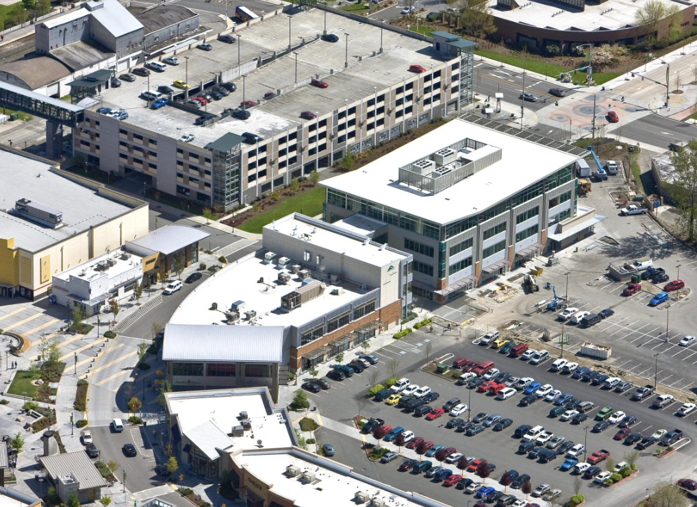 A shopping mart in kent washington on a sunny day. Drone shot viewing the white, flat roofs of the retail stores.